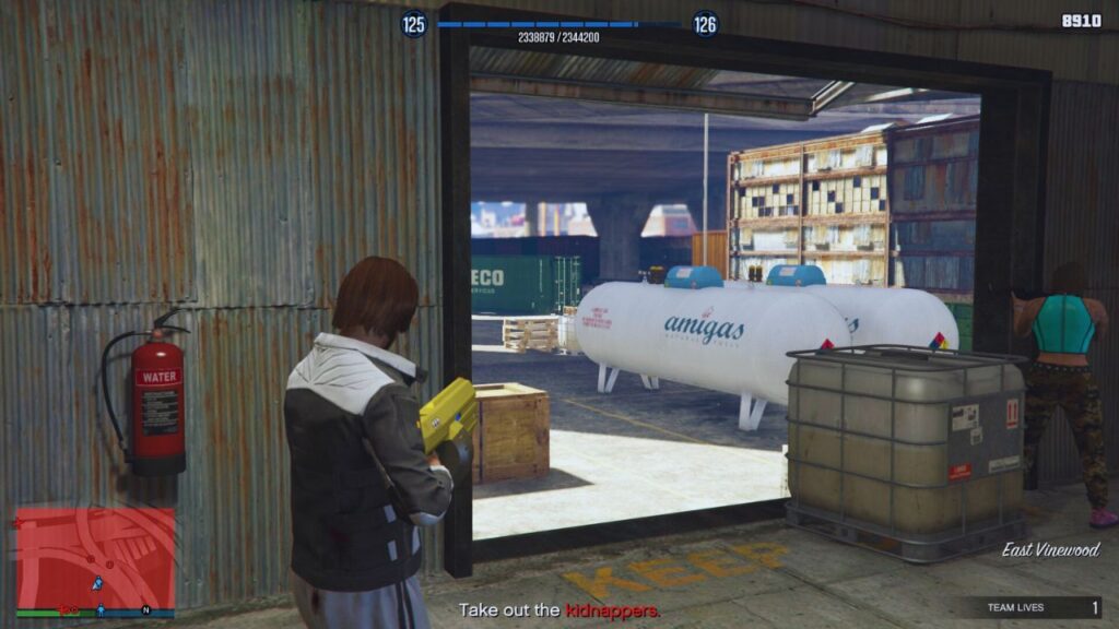 The GTA Online aiming the Unholy Hellbringer at the Amigas Explosive Gas Tank near Lucha outside The Freakshop.
